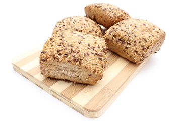 Wholemeal rolls on cutting board isolated on white background