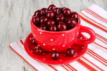 Sweet cherry in cup on table close-up
