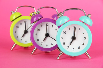 Colorful alarm clock on pink background