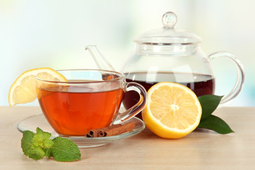 Cup of tea with lemon on table on light background