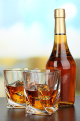 Glass of whiskey with bottle, on dark background