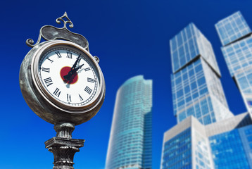 town clock on the background of modern skyscrapers