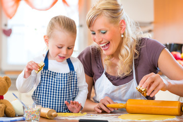 Mutter und Tochter backen Plätzchen in Küche