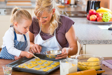 Mutter und Tochter backen Plätzchen in Küche
