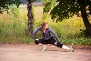 Runner woman stretching in nature outdoor