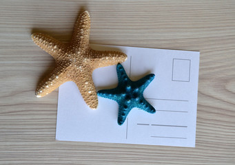 Tarjeta postal sobre escritorio con adornos de estrellas de mar