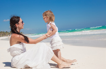 Young beautiful mother and her adorable little daughter at