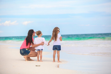 Fototapeta premium Rear view of fashion young mother and two her kids at exotic