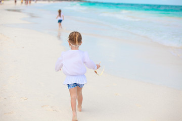 Little girl running on white sandy beach in Mexico