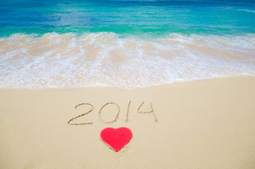 Number 2014 and heart shape on the beach