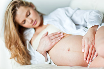 Fototapeta na wymiar Young pregnant woman resting on sofa