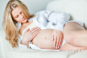 Obraz na płótnie Canvas Young pregnant woman resting on sofa