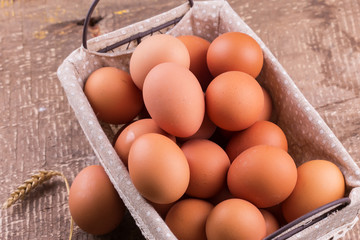 Eggs in bucket on wooden background