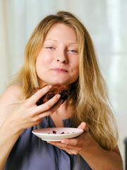 Female enjoying a chocolate brownie - 54855550