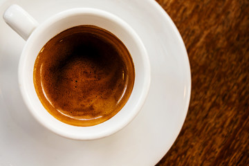 White cup of coffee on wooden background