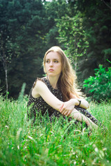 woman sits at a forest's meadow