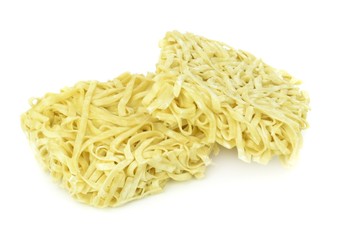 Two blocks of dried egg noodles on a white background