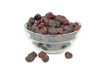A bowl of dried cranberries in a glass bowl on white background