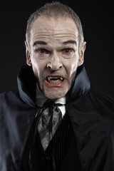 Naklejka premium Dracula with black cape showing his scary teeth. Vamp fangs. Stu
