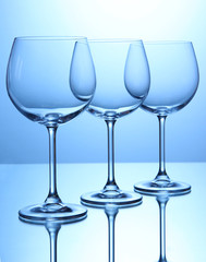 Empty wine glasses arranged on blue background