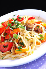 Noodles with vegetables on plate close-up
