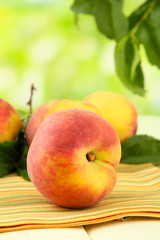 Ripe sweet peaches on wooden table in garden, close up