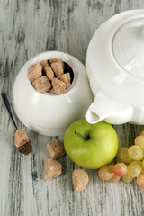 Unrefined sugar in white sugar bowl on wooden background