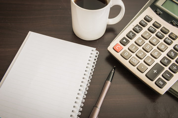 Coffee cup, Document file , pen , Calculator , notepad  on woode