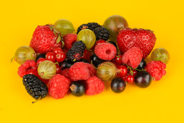 Ripe berries on yellow background