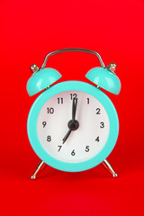 Blue alarm clock on red background