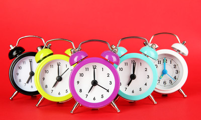 Colorful alarm clock on red background