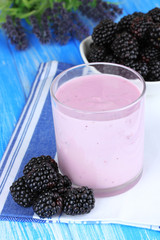 Sweet blackberries with yogurt on table close-up