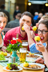 Leute in Bayerischer Tracht essen in Restaurant