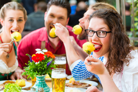 Leute in Bayerischer Tracht essen in Restaurant