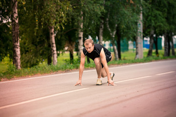 Sportive man in starting position prepared to run