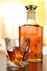 Glass of whiskey with bottle, on dark background