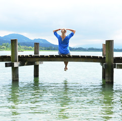Fototapeta premium Girl on the wooden jetty. Switzerland
