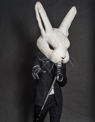 man in rabbit mask . black suit sing on dark background - 54867580