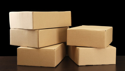 Parcels boxes on wooden table, on black background