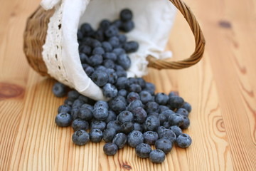 auf Holztisch liegende Blaubeeren mit Körbchen