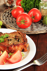 Piece of fried meat on plate on wooden table close-up