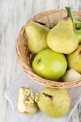 Pears in basket on board on wooden table
