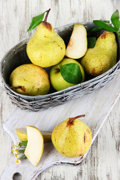 Pears in basket on board on wooden table