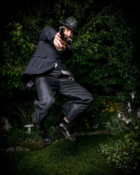 Man with Gun in Retro Suit Jumping