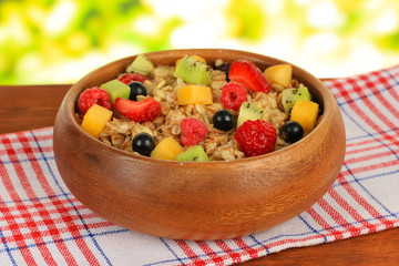 Oatmeal with fruits on table on bright background