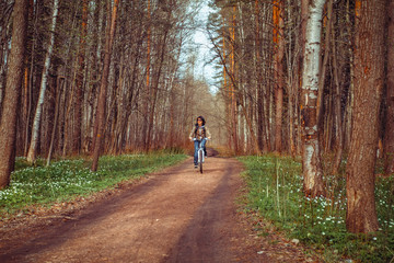 Obraz premium Young lady with bicycle on a road