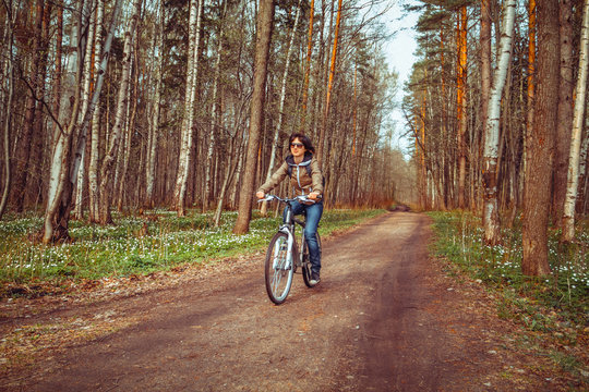 Young woman riding bicycle on a forest