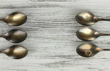 Vintage metal spoons on wooden table close-up