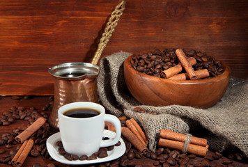Coffee cup and metal turk on wooden background