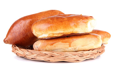 Fresh baked pasties on  wicker plate, isolated on white